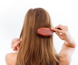 Woman combing her beautiful healthy hair.